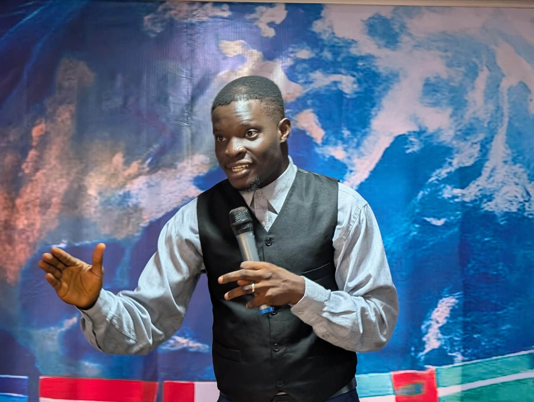 Preaching with the nations backdrop behind, at a BLCN service